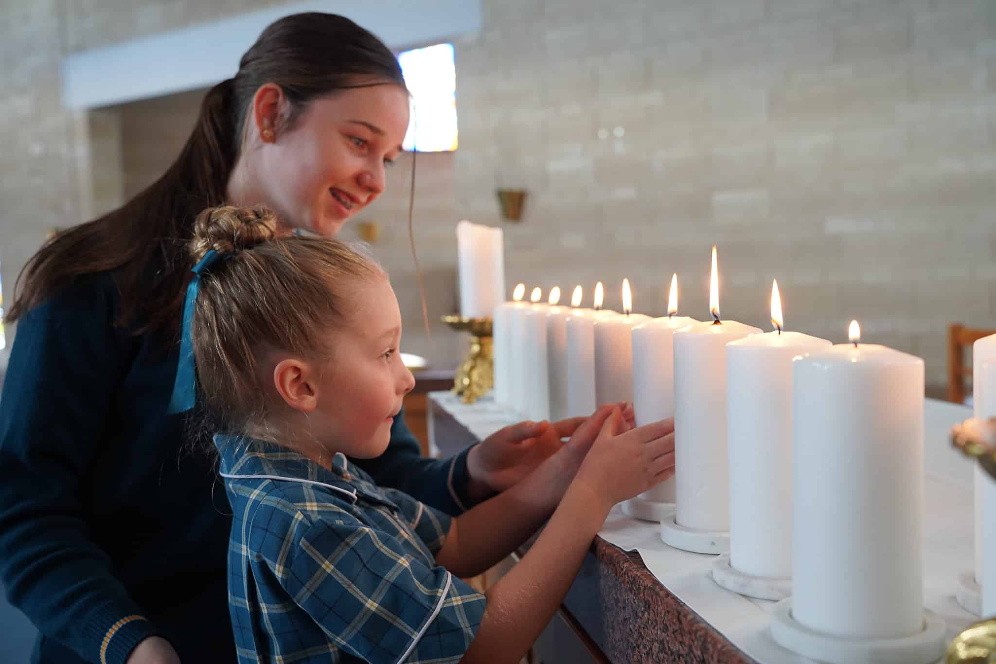 Students placing candles on church alter