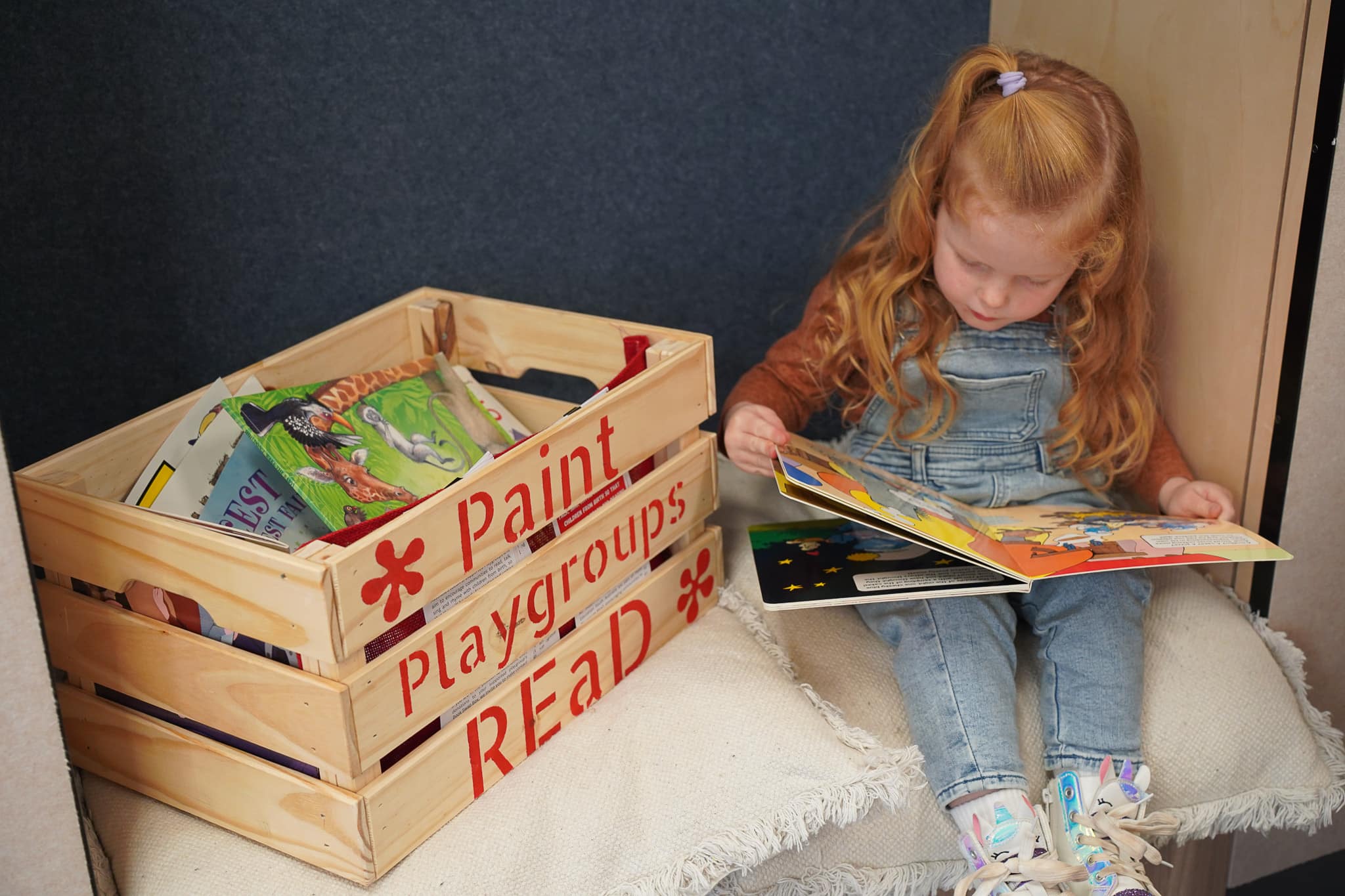 Child reading a book during playgroup activities