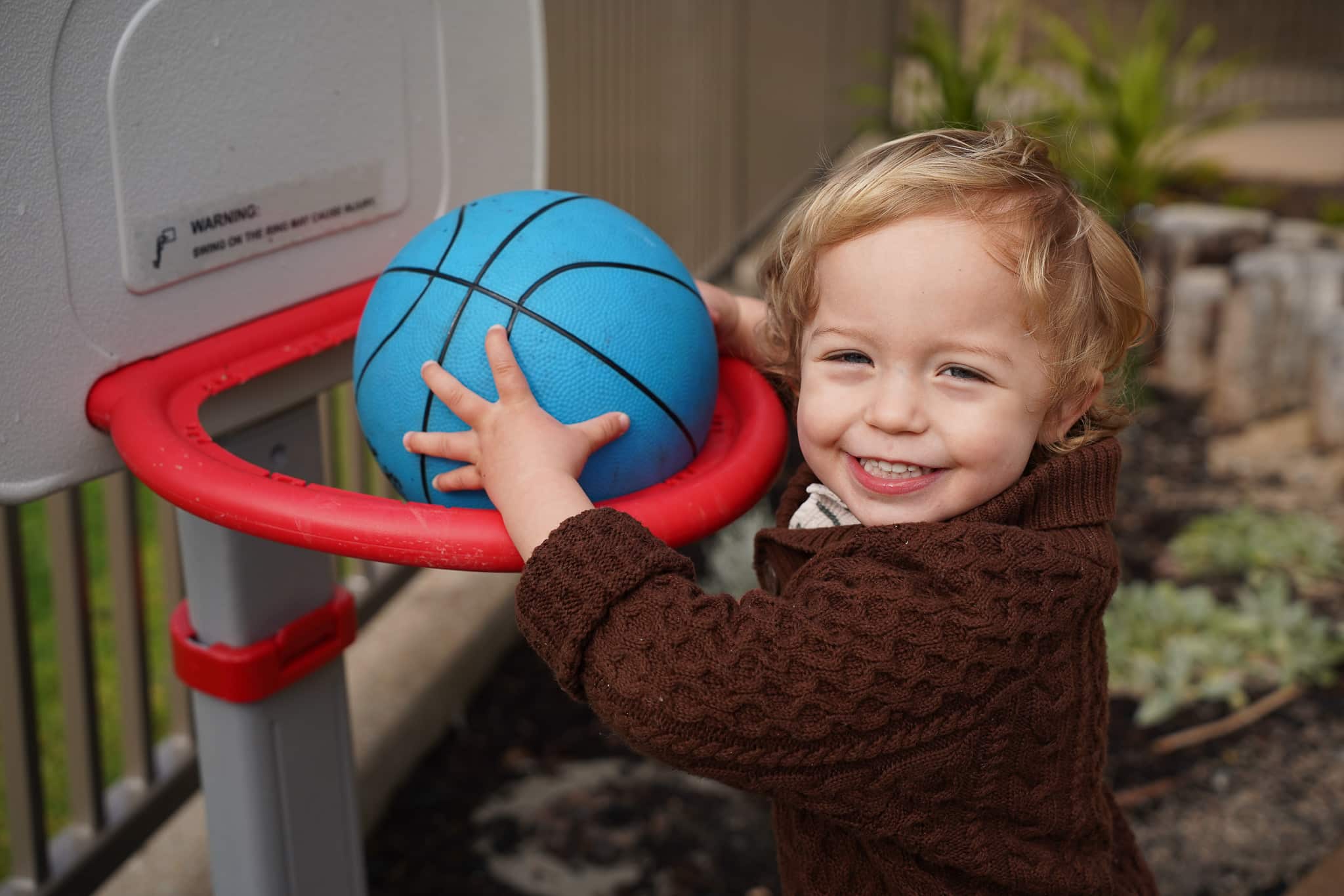 Child playing with a ball outdoors during playgroup