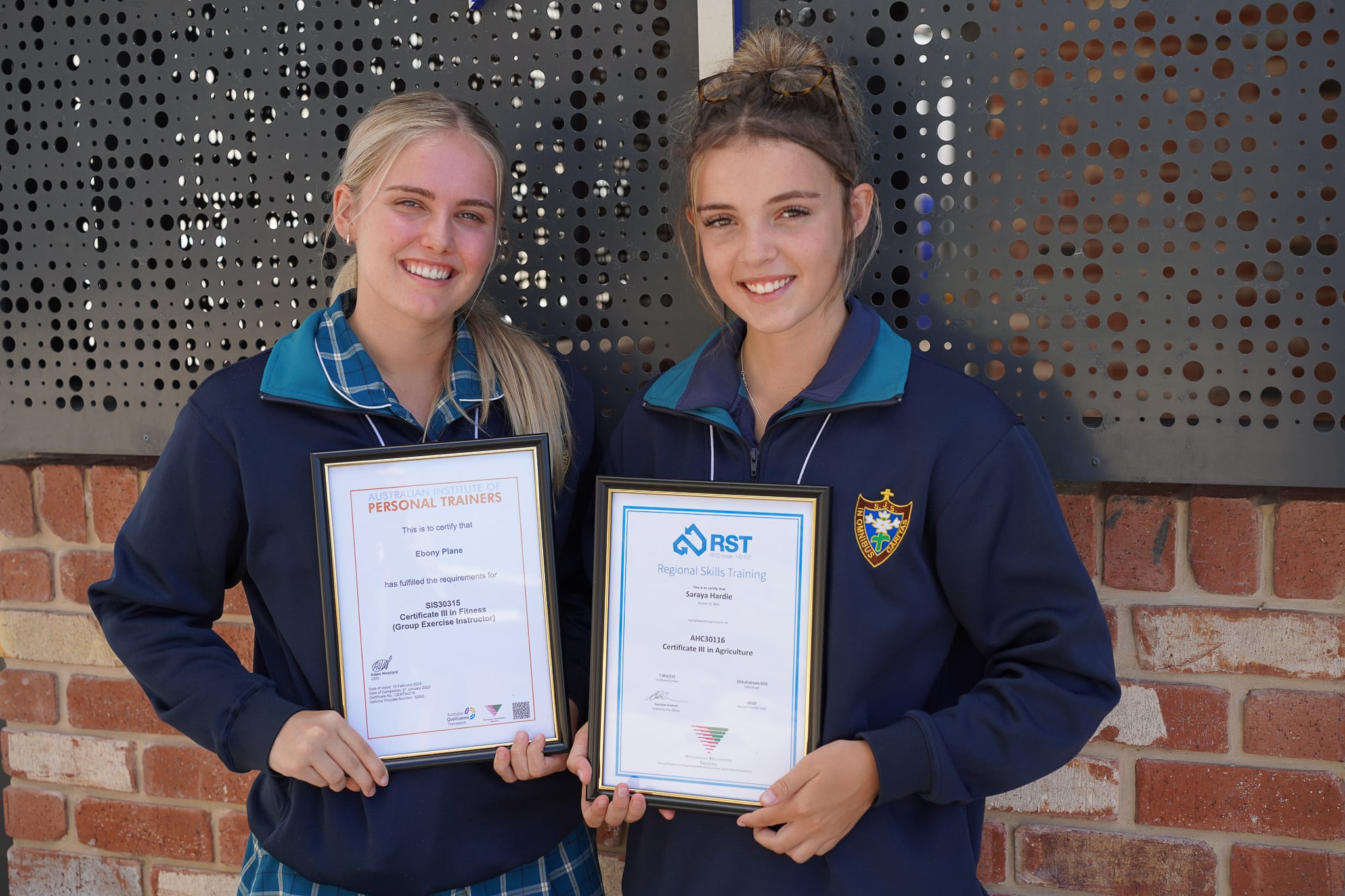 Students holding their qualification certificates